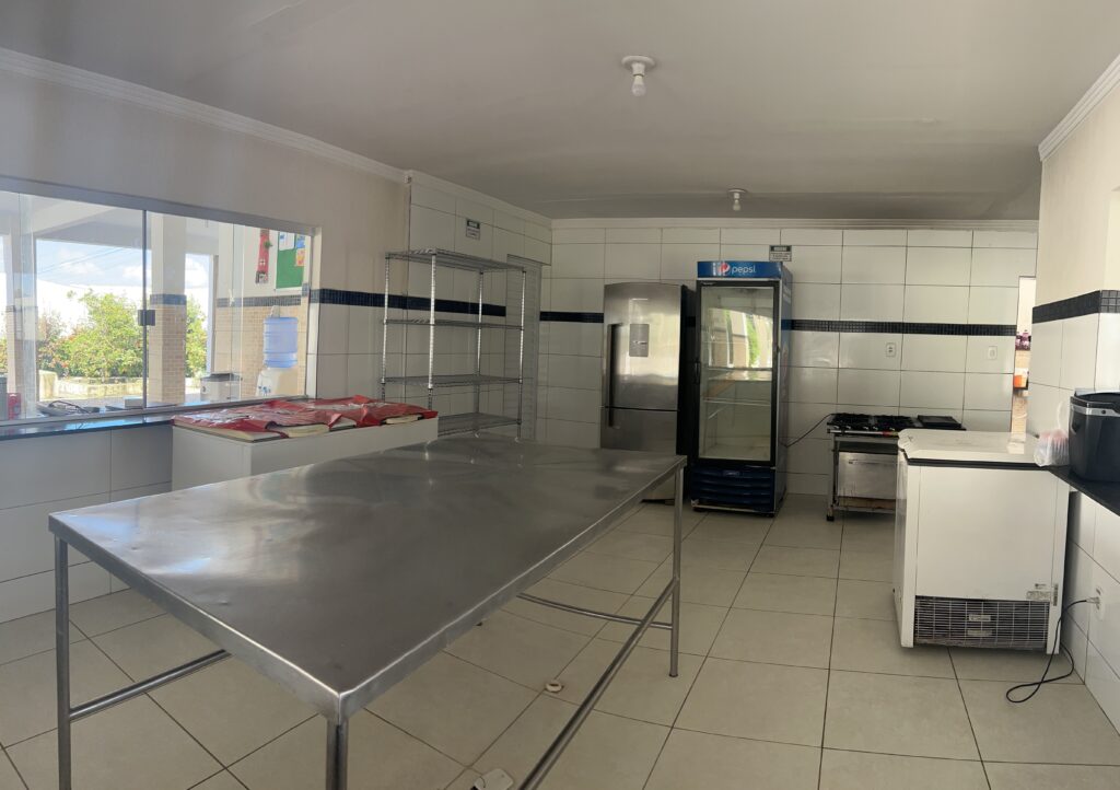 Cozinha industrial da Chácara da Serra com bancada de inox, freezer e fogão industrial