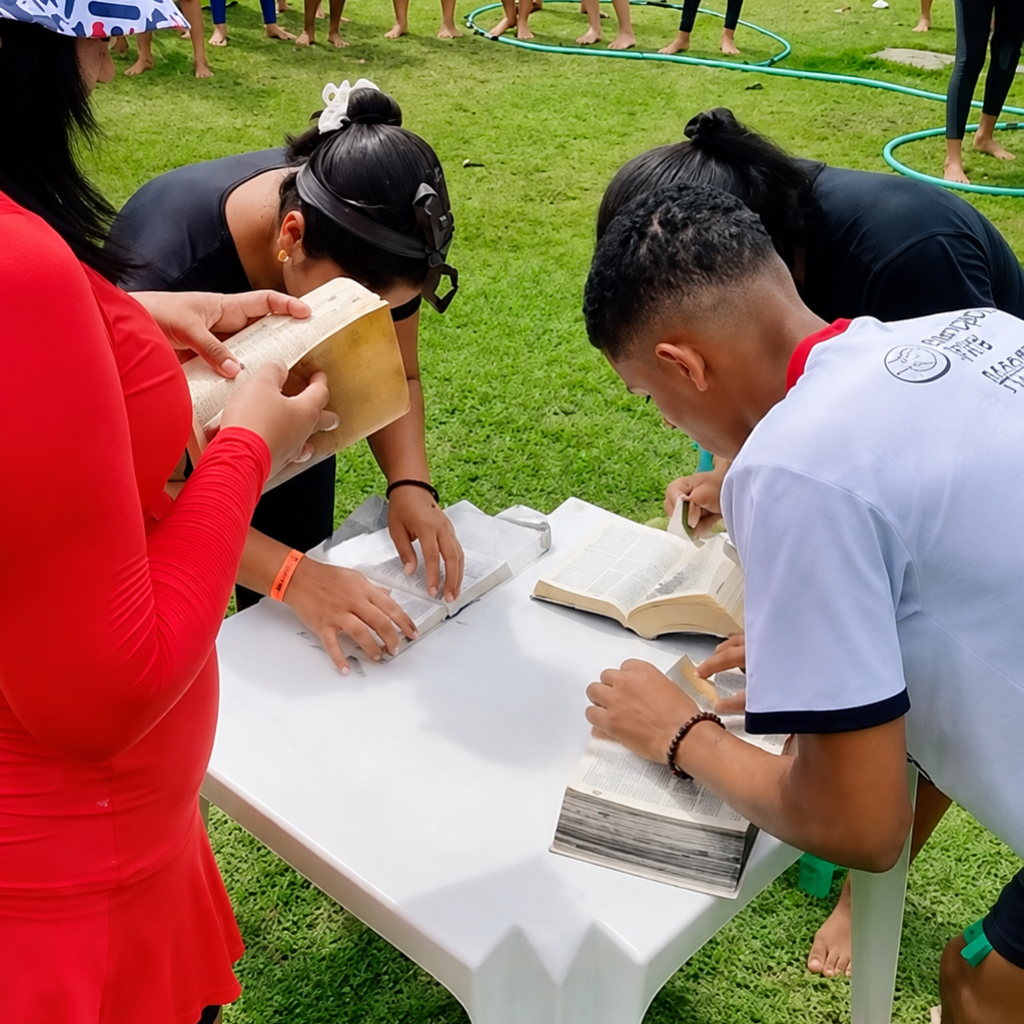 Equipe procurando versículos na Bíblia durante o desafio bíblico em grupo