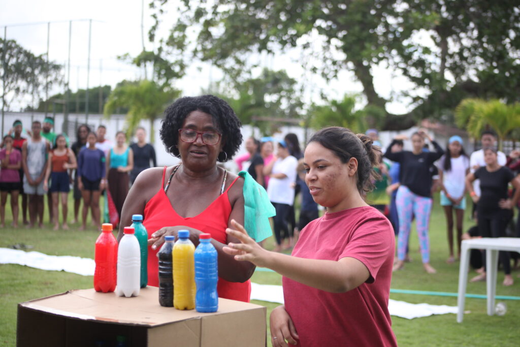 Jovens montando a sequência de garrafas coloridas na brincadeira das cores, durante retiro na Chácara da Serra
